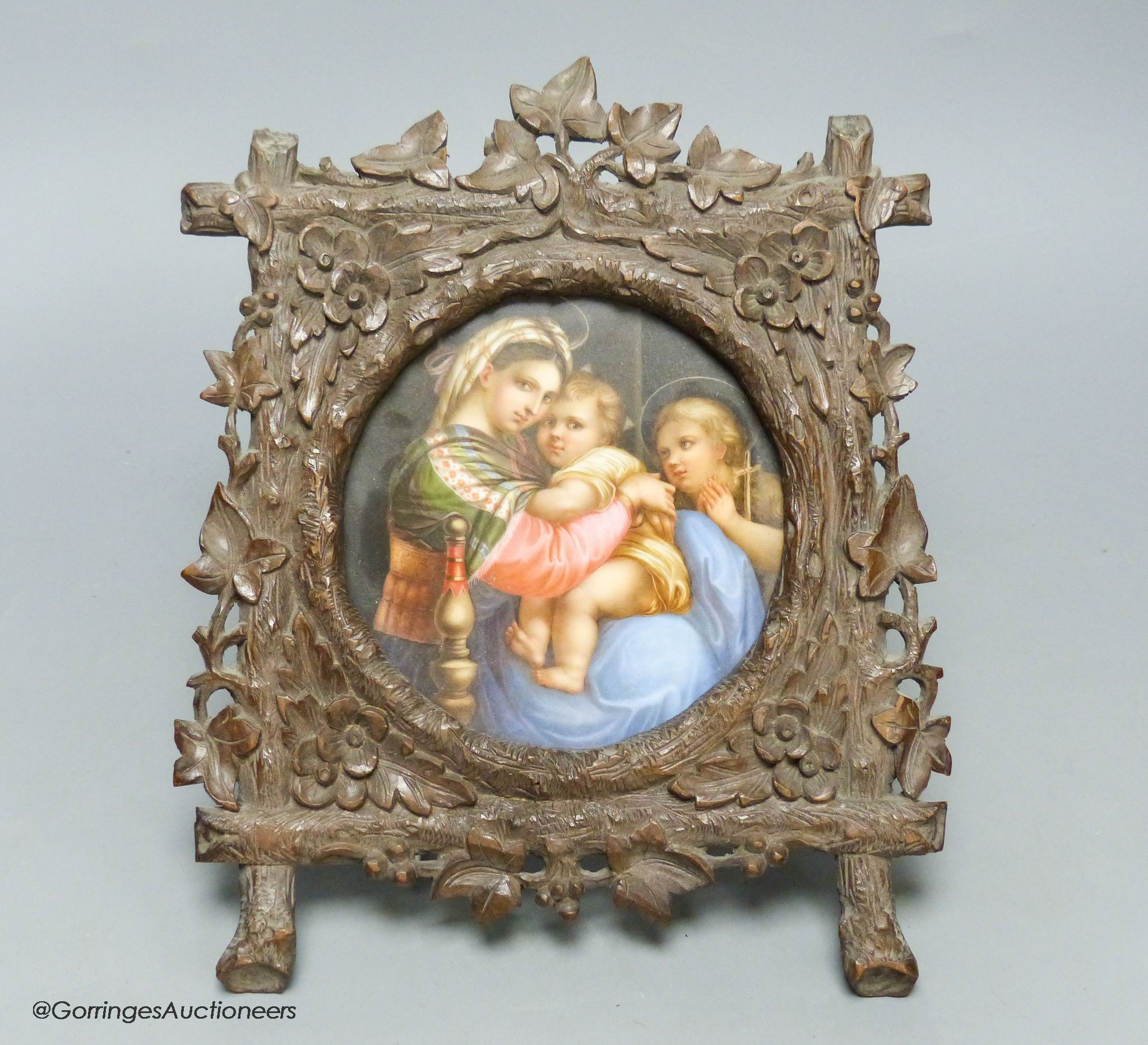 A late 19th century Paris porcelain plaque, depicting Madonna della Sedia, in Black Forest carved frame, width 19cm height 25cm overall